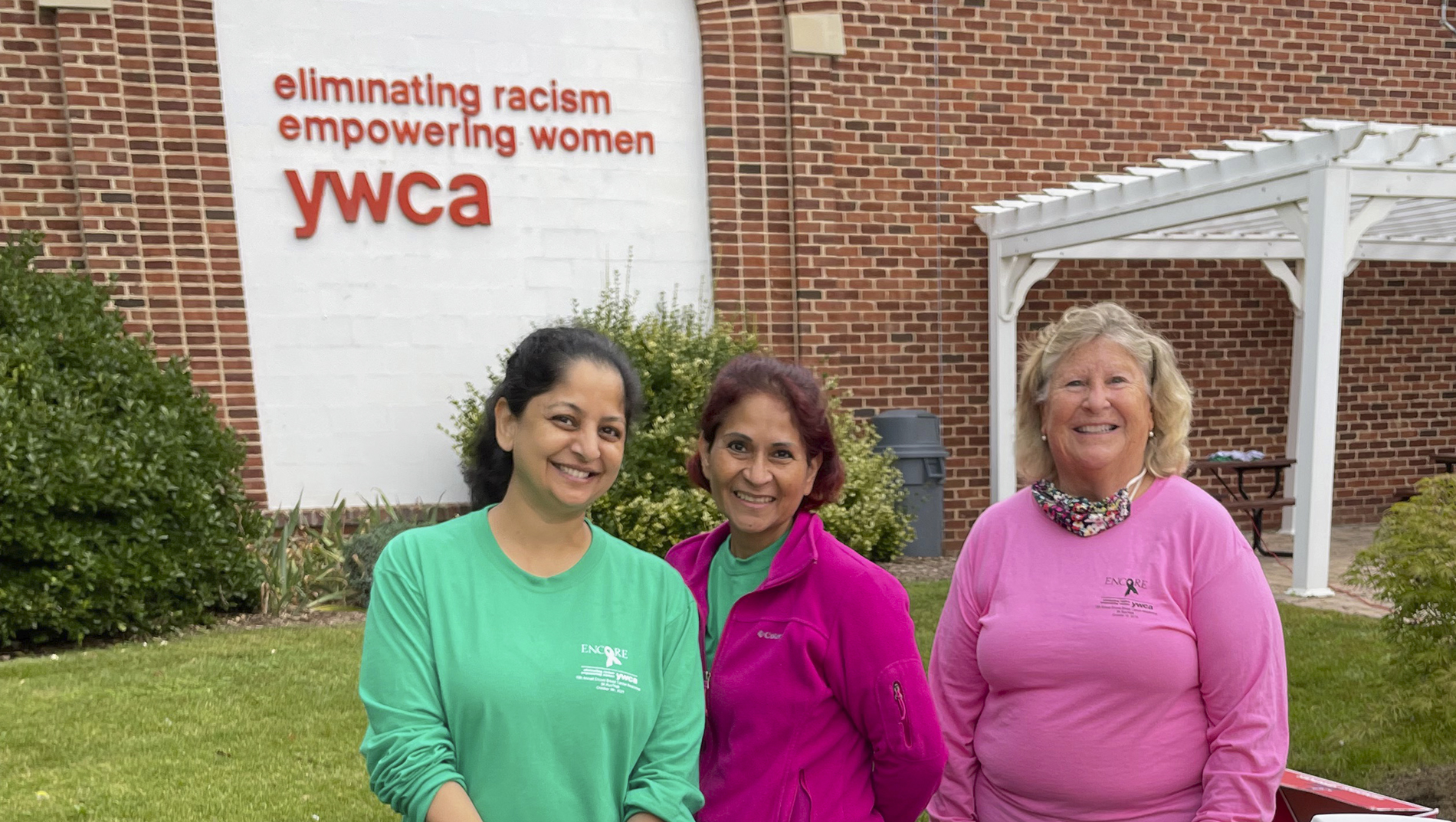 Three women standing in front of the YWCA.