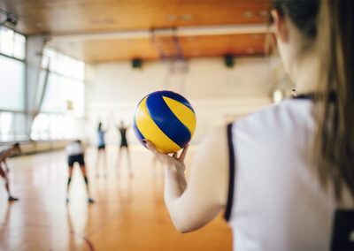 Person holding a volleyball getting ready to play a game.