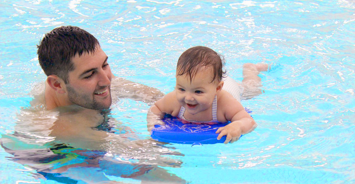 Man swimming with infant